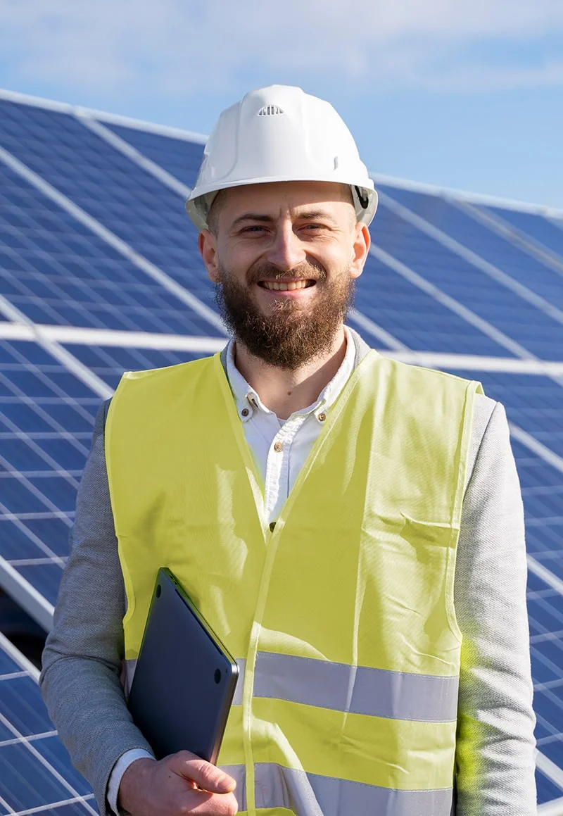 Smiling solar panel technician holding tablet.